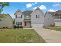 Charming two-story home featuring gray siding, a red front door, and a well-maintained lawn at 3945 Hamilton Cove Ct, Cumming, GA 30028