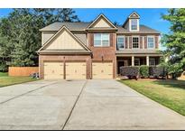 Charming two-story home with a brick facade, a manicured lawn, and a spacious three-car driveway at 1606 Kenilworth Se Ln, Conyers, GA 30013