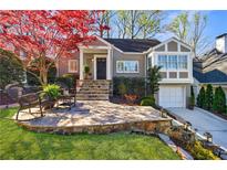Charming home with stone patio, lush lawn, and vibrant trees at 1287 University Ne Dr, Atlanta, GA 30306