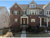 Charming townhome with a red brick facade, black shutters and a landscaped yard at 2736 Bell Se Dr, Smyrna, GA 30080