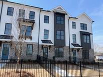 Modern townhome featuring painted brick, black trim, and a black metal fence at 623 Silva St # 130, Cumming, GA 30040