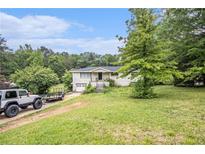 A charming brick ranch-style home with a spacious front yard and mature trees at 8600 Andy Mountain Ct, Villa Rica, GA 30180