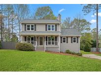 Charming two-story home featuring a well-manicured lawn, neutral siding, and welcoming front porch at 2217 Sims Ne Dr, Marietta, GA 30066