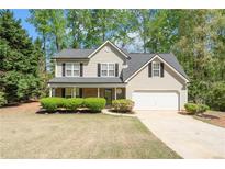 Charming two-story home with a well-maintained lawn, attached garage, and mature trees at 4315 Summit Heights Dr, Snellville, GA 30039