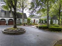 Charming home with a circular driveway, a brick facade, and meticulously manicured landscaping at 3900 Randall Ridge Nw Rd, Atlanta, GA 30327