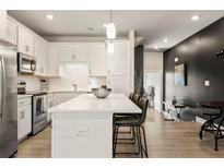 Modern kitchen featuring white cabinets, stainless steel appliances, and a large island with counter seating at 2030 Main Nw St # 207, Atlanta, GA 30318