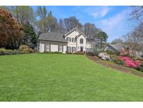 Charming two-story traditional home with manicured front lawn and colorful azaleas at 1201 Lake Washington Dr, Lawrenceville, GA 30043