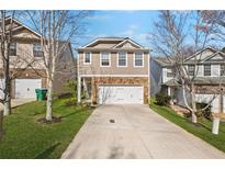 Charming two-story home featuring stone accents, a two-car garage, and a well-manicured front lawn at 313 Hidden Creek Lane, Canton, GA 30114