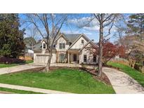 Charming two-story home featuring a well-manicured lawn, circular driveway, and mature trees in a desirable neighborhood at 5489 White Cedar Ter, Sugar Hill, GA 30518
