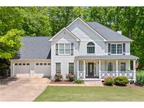 Charming two-story home with a three-car garage, landscaped front yard, and welcoming front porch at 100 Oakwind Pkwy, Canton, GA 30114