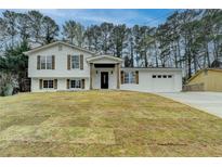 Charming two-story home featuring a well-manicured lawn and a two-car garage at 5155 Rosestone Nw Dr, Lilburn, GA 30047
