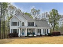 Traditional two-story home with a manicured lawn, charming front porch, and classic architectural details at 819 Holly Rdg, Canton, GA 30115