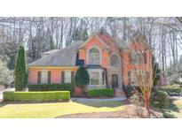 Charming two-story brick home featuring well-manicured landscaping and a welcoming front entrance at 5190 Deerlake Dr, Alpharetta, GA 30005