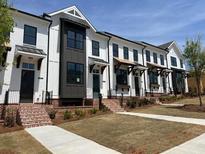 New townhouse exteriors feature white siding, dark accents, brick stairs and manicured lawns at 634 Skytop Dr # 155, Cumming, GA 30040