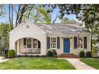Charming home with a blue door, rocking chairs on the front porch, and a well-manicured lawn at 26 Standish Nw Ave, Atlanta, GA 30309