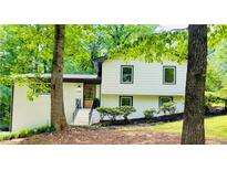 Charming split-level home featuring a brick facade, new windows, and lush landscaping at 3306 Sleepy Se Ln, Smyrna, GA 30080