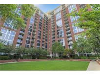 Beautiful red brick condo building with lush green lawn, trees, and landscaping at 1820 Peachtree Nw St # 608, Atlanta, GA 30309