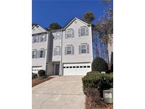 Attractive townhouse with a two-car garage, blue shutters, and well-maintained landscaping at 190 Abbotts Mill Dr, Duluth, GA 30097