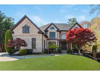 Charming two-story brick home with a manicured lawn and mature trees creating a welcoming curb appeal at 2461 Oak Grove Ne Ests, Atlanta, GA 30345