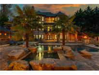 Luxury home with stunning pool, rock features, palm trees, and outdoor entertaining area at 2461 Oak Grove Ne Ests, Atlanta, GA 30345