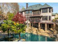 Luxury home features a sparkling pool, detailed brickwork, and meticulously landscaped backyard at 2461 Oak Grove Ne Ests, Atlanta, GA 30345