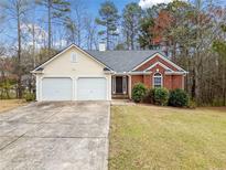 Charming single-story home with a two-car garage, brick accents, and a well-maintained lawn and traditional curb appeal at 57 Sorghum Ct, Dallas, GA 30157