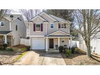 Charming two-story home featuring neutral siding, a single-car garage, and a cozy front porch at 411 Sureyya Dr, Canton, GA 30114