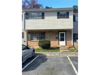Two-story townhouse featuring brick and siding, complemented by black shutters and a paved parking area at 4701 Flat Shoals Rd, Union City, GA 30291