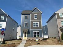 New construction two-story home featuring a yellow front door, brick foundation, and blue and gray siding at 1366 Creekside Nw Cir, Atlanta, GA 30318