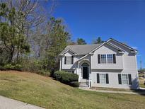 Charming two-story home with vinyl siding and a well-manicured lawn on a sunny day at 68 Georgias Ln, Dallas, GA 30157