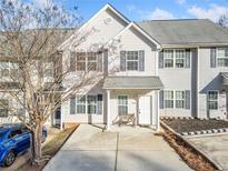 Charming townhome featuring a well-manicured front yard with driveway and covered porch at 258 Venture Path, Hiram, GA 30141