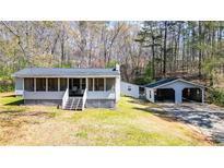 Charming home featuring a screened porch, detached garage, and a peaceful, wooded lot at 528 Lower Scott Mill Rd, Canton, GA 30114
