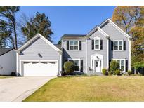 Charming two-story home with a well-maintained lawn and attached two-car garage on a sunny day at 302 Cimarron Way, Lawrenceville, GA 30044