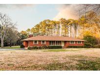 Charming brick ranch-style home with a well-maintained lawn and mature trees in a tranquil setting at 3856 Egypt Rd, Snellville, GA 30039