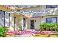 Renovated townhouse with cream siding and well-maintained landscaping at 1124 Country Ct, Lawrenceville, GA 30044