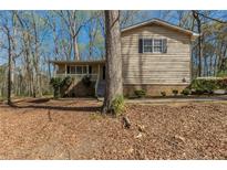 Charming single-story home with a covered porch and mature trees surrounding the property at 3637 Windmill Rd, Ellenwood, GA 30294