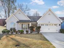 Charming one-story home featuring manicured landscaping, attached garage, and a welcoming front porch at 5180 Sterling Trace Nw Ct, Lilburn, GA 30047
