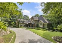 Charming home featuring a stone and siding exterior with a long driveway and mature trees at 2160 Bradley Trl, Cumming, GA 30041