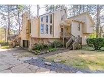 View of the two-story home with wood and stone and a wooden stair walkway up to the front door at 752 Alison Jane Ne Ct, Kennesaw, GA 30144