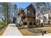 Contemporary two-story home showcasing a modern design with a dark exterior and wooden balconies and trim at 1792 Charles Nw Pl, Atlanta, GA 30318