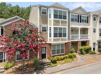 Inviting townhouse showcasing a beautifully landscaped front and multi-level facade with a flowering tree at 223 Riverstone Commons Cir, Canton, GA 30114