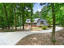 Charming single-Gathering home with landscaped front yard and a long concrete driveway surrounded by mature trees at 4720 Timberland Sw Dr, Mableton, GA 30126