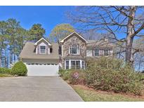 Charming two-story home featuring a stone facade, dormer windows, and an attached two-car garage at 962 Cove Lake Ct, Lawrenceville, GA 30045