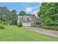 Charming two-story home with stone accents, a well-manicured lawn, and an attached two-car garage at 962 Cove Lake Ct, Lawrenceville, GA 30045