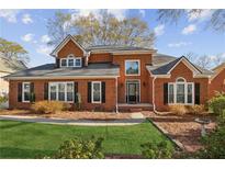 Charming two-story red brick home with well-manicured lawn and mature landscaping at 321 Covered Bridge Sw Pl, Smyrna, GA 30082