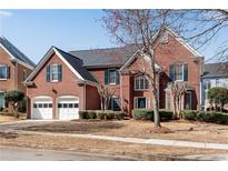 Charming two-story brick home featuring a two-car garage and manicured landscaping at 1107 Carroll Ct, Norcross, GA 30071