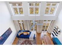 Bright living room featuring high ceilings, large windows, and a stylish blue sofa with a decorative rug at 1221 Caroline Ne St # 201, Atlanta, GA 30307