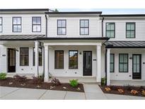 Charming townhome with white siding, black trim, and inviting front porch at 58 Black Gum Ln # 47, Auburn, GA 30011