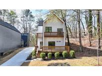 New construction modern home with a white facade, wood-accented balconies and a welcoming front porch at 1800 Charles Nw Pl, Atlanta, GA 30318