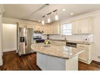 Bright eat-in kitchen features an island, stainless steel appliances, and white subway tile backsplash at 3427 Springlake Dr, Decatur, GA 30032